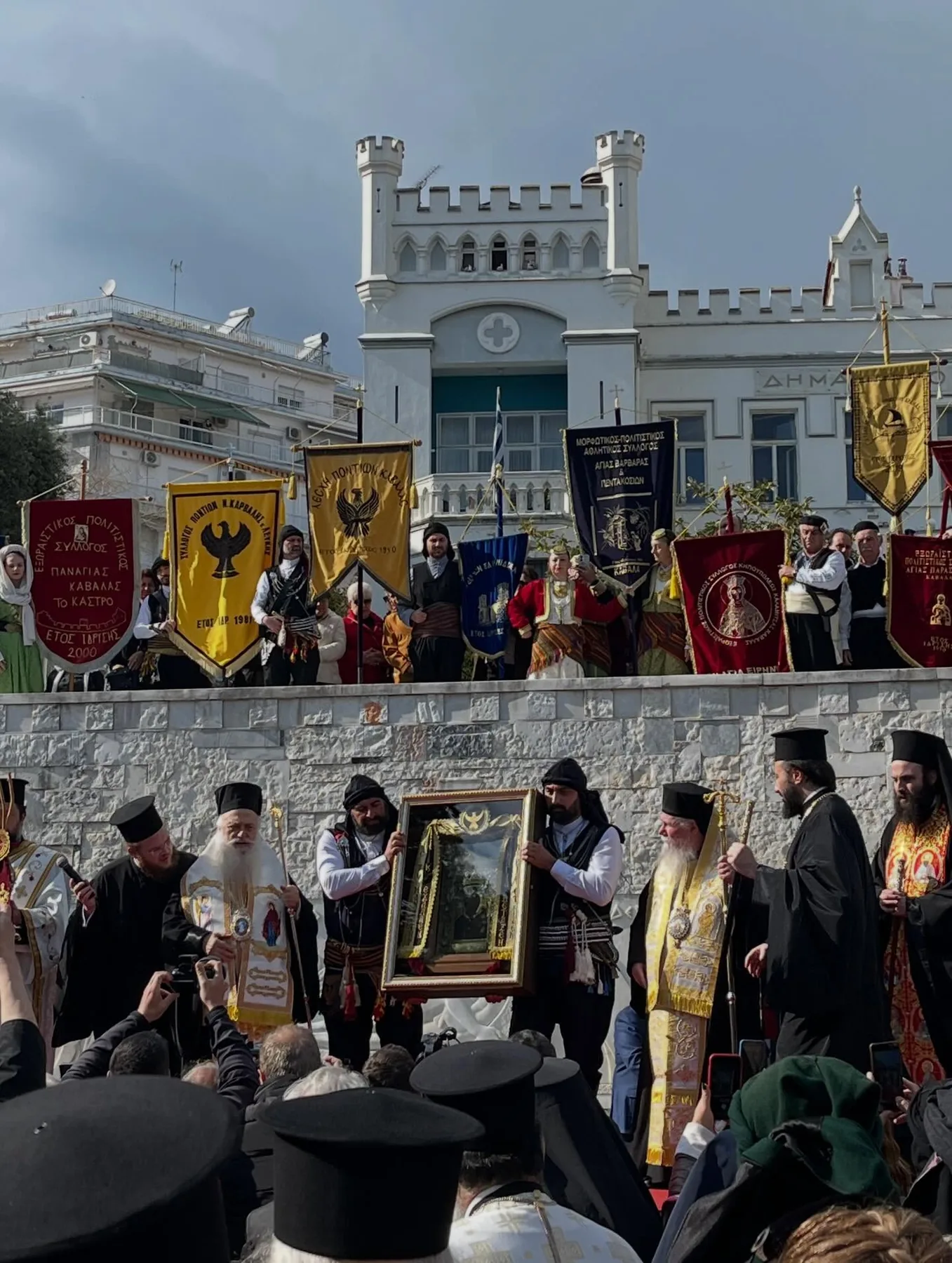Λιτανεία εικόνας με λάβαρα μπροστά από το δημαρχείο
